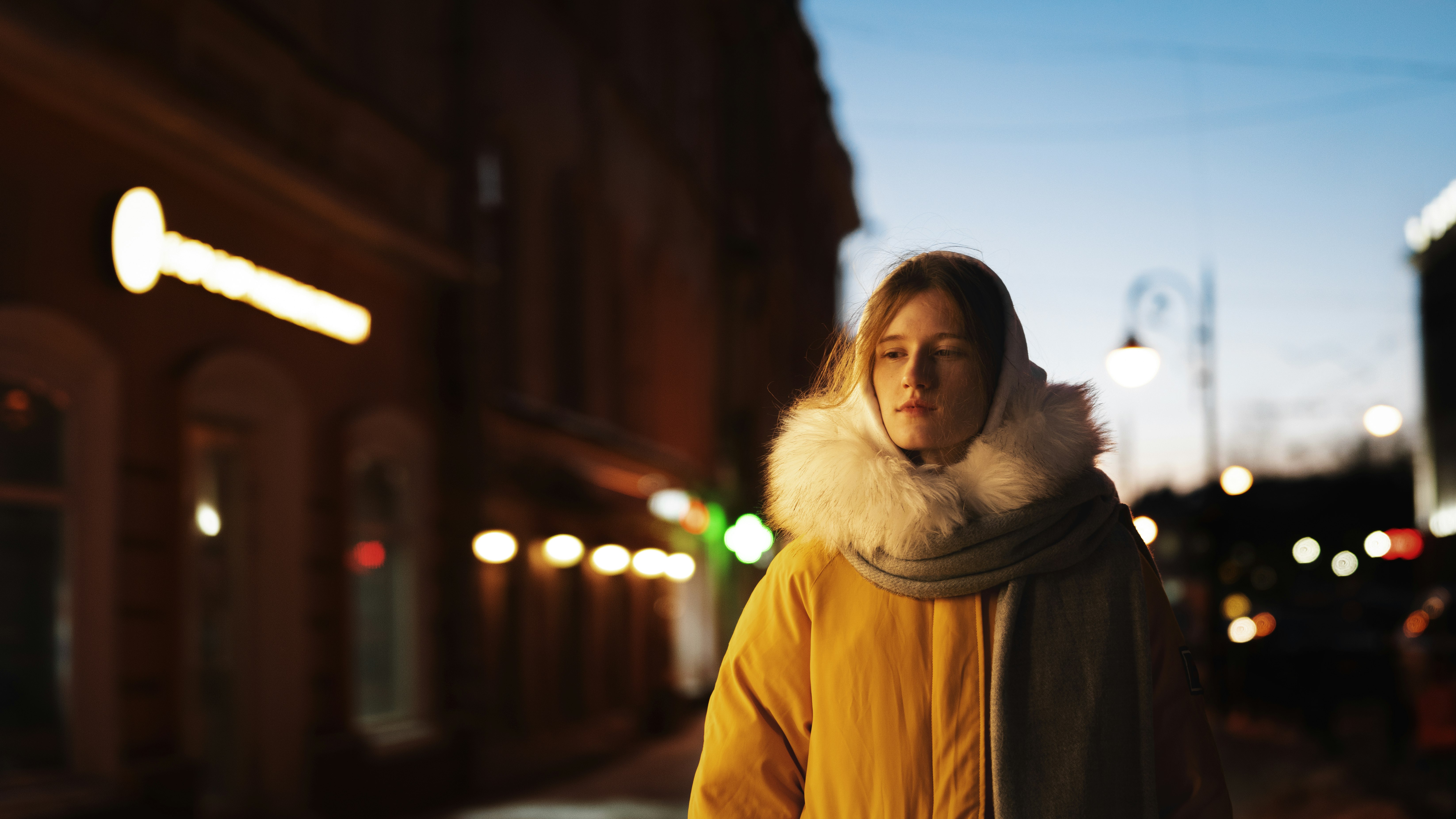 woman in yellow jacket standing on road during daytime